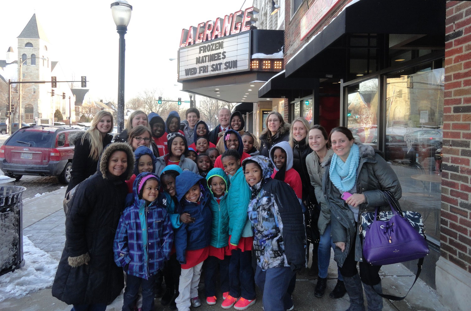 Photo of SPM employees and children of the Off The Street Club in front of the La Grange theatre.